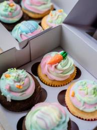 cupcakes with white icing and green and pink icing on top