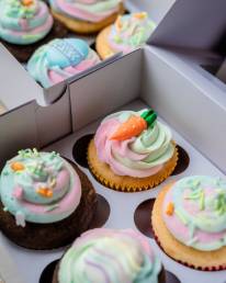 cupcakes with white icing and green and pink icing on top